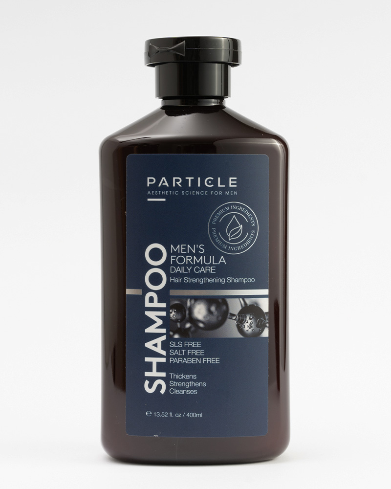 A black bottle of Particle Men’s Formula Daily Care Hair Strengthening Shampoo.