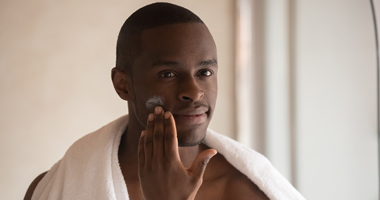 Young_man_enjoying-face-cream-looking-at-himself-in-the-mirror