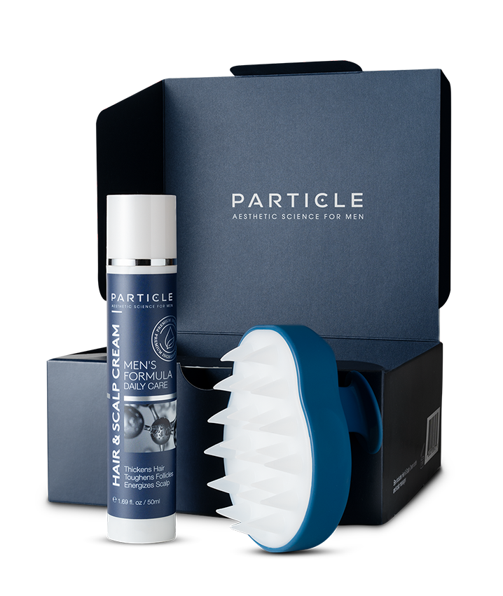Particle hair and scalp cream and massager near blue box.