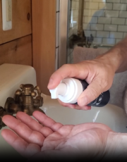 Hands dispensing foam from a Particle pump bottle.